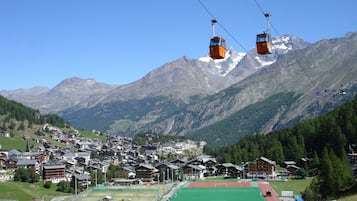 En bjerglandsby med traditionelle huse, en sportsplads og en skilift.