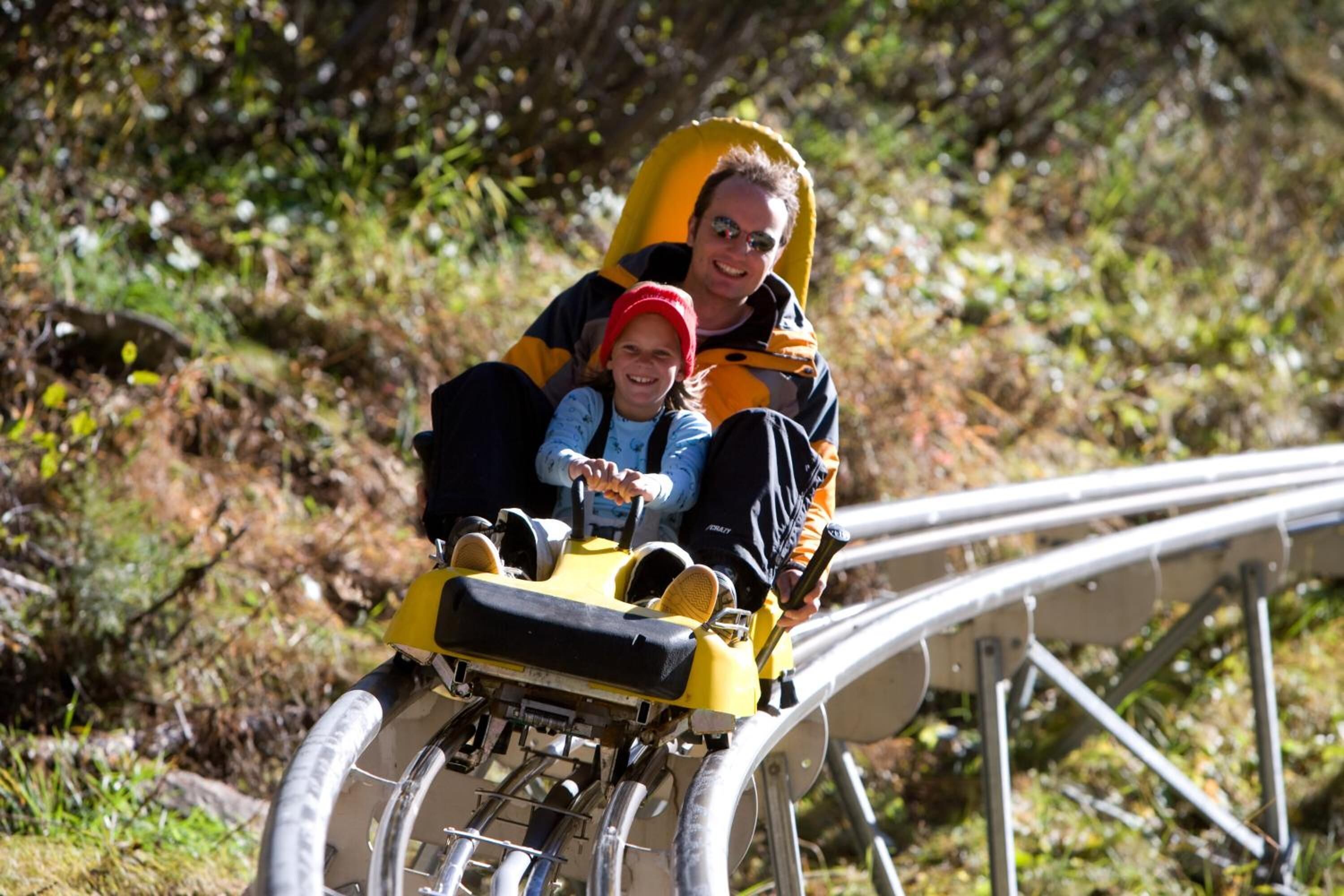 Eine Person in einem gelb-schwarzen Kostüm auf der Strecke einer Achterbahn.