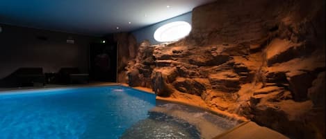 Una piscina techada, sillones reclinables de piscina