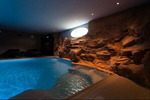 Una piscina techada, sillones reclinables de piscina