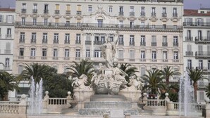 Un edificio histórico con una gran escalera y una estatua en su fachada.