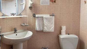 Une salle de bain équipée d’un lavabo, d’un bidet, de toilettes et d’un miroir.