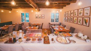 Comedor con mesas, sillas y un bufé con diferentes opciones de comida.