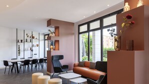 A modern interior with a dining area, seating, and a large window. - B&B Hotel Sassuolo (Sassuolo)