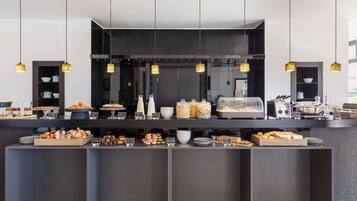 A modern breakfast bar with a variety of pastries and breakfast items.