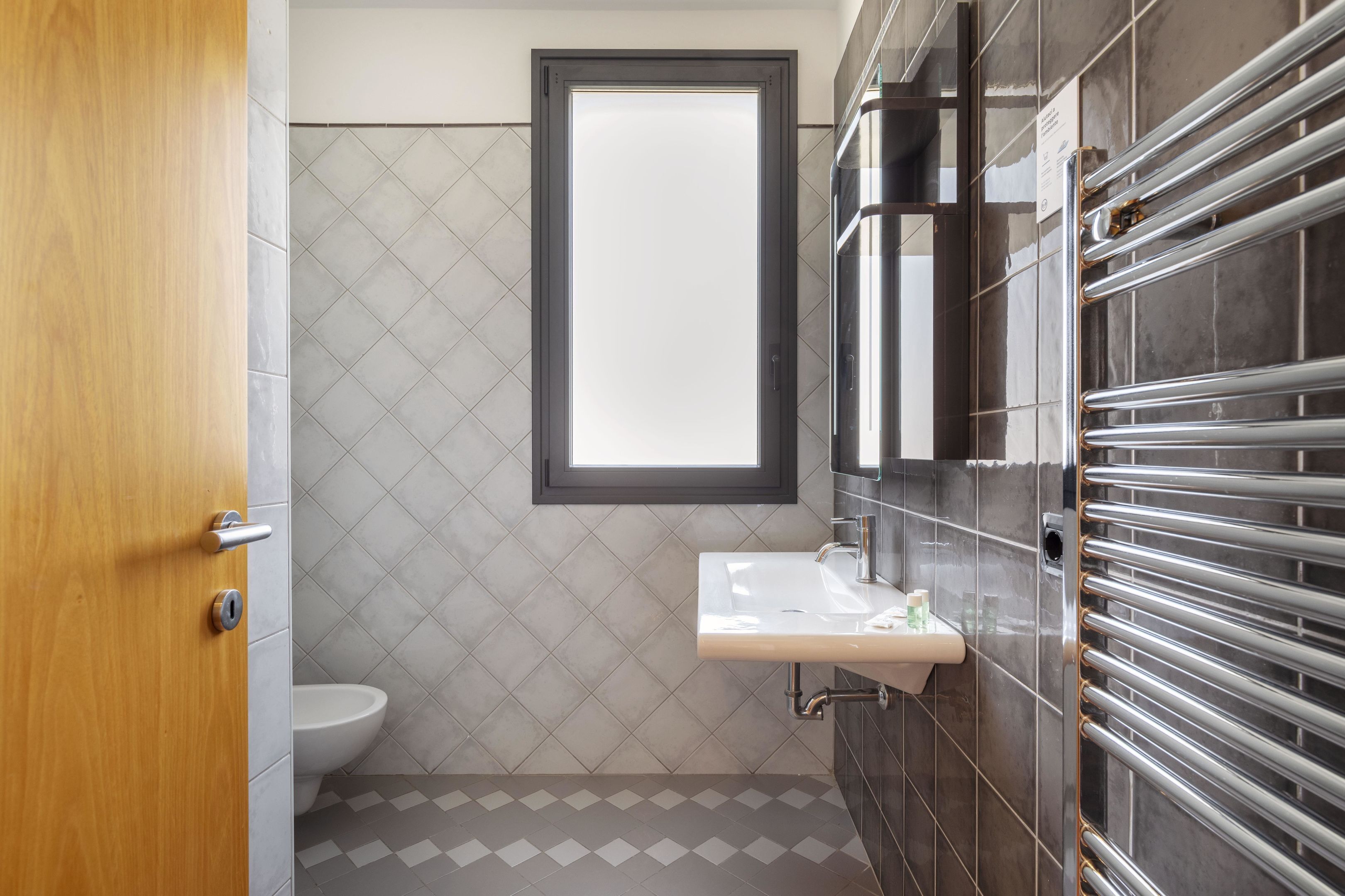Un baño moderno con inodoro, lavamanos y toallero.