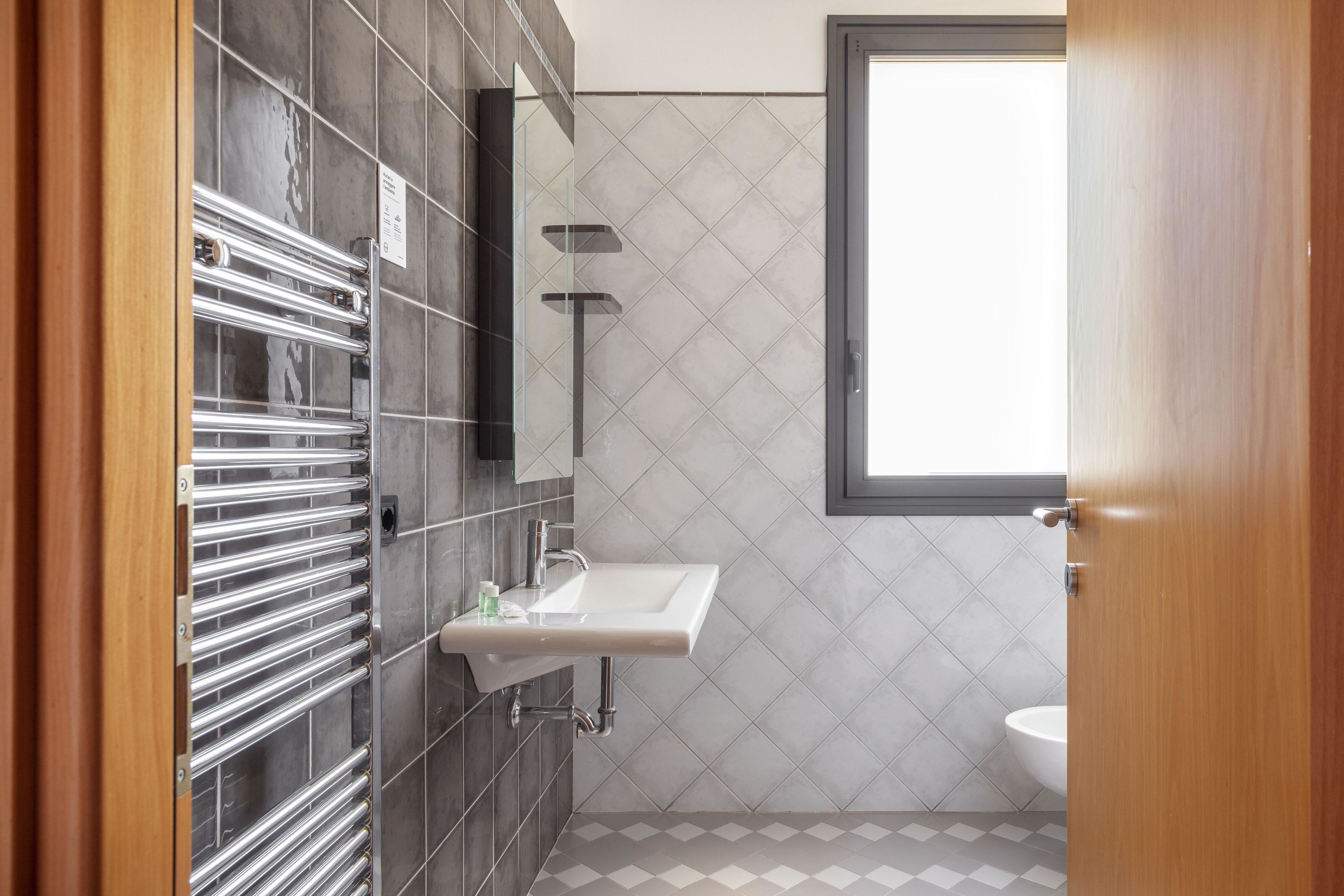 A modern bathroom with a glass shower enclosure, a sink, and a toilet.