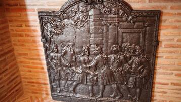 A detailed metal relief sculpture on a brick wall.