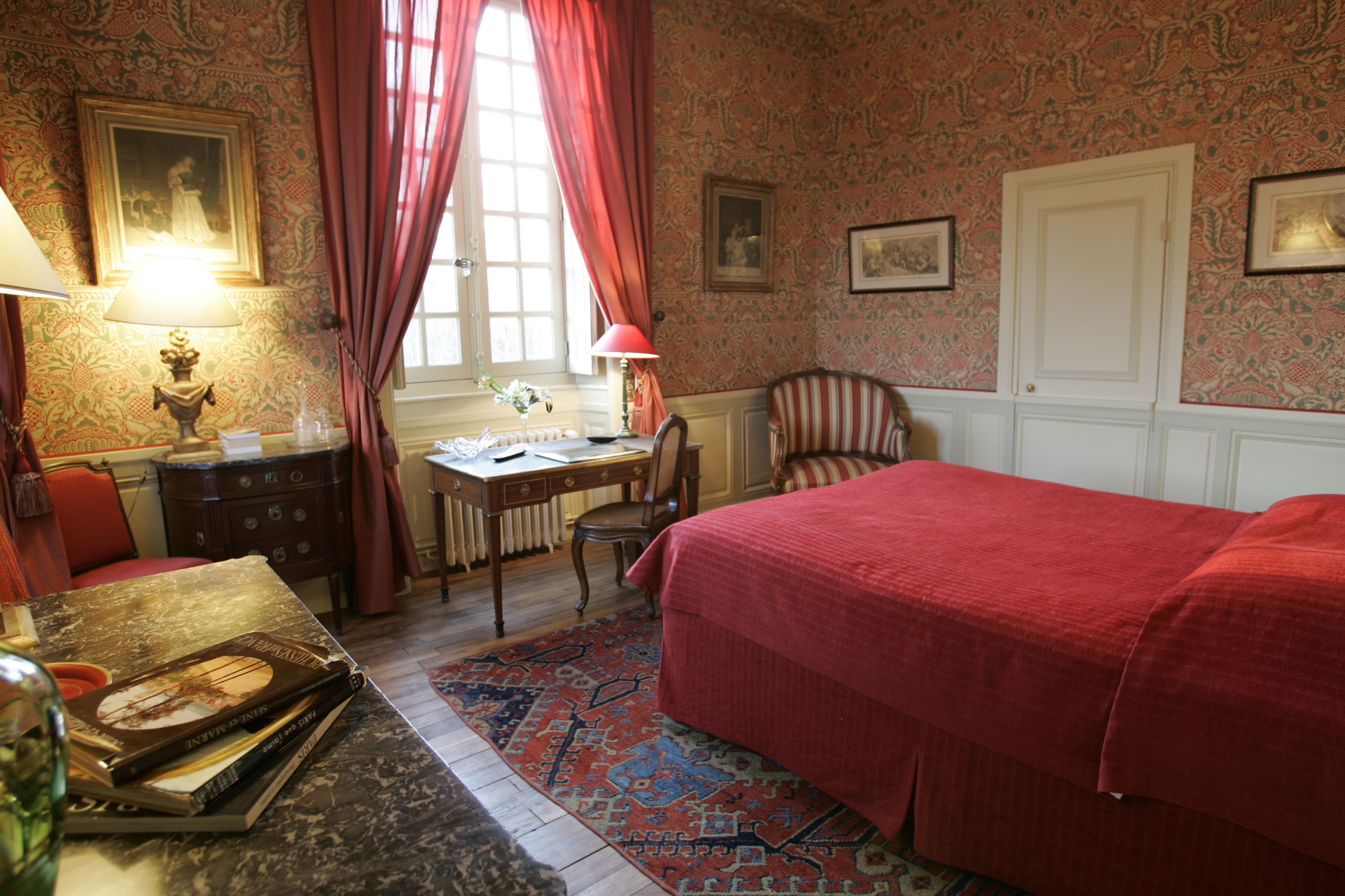 A room with a bed, a desk, a chair, a lamp, and a radiator.