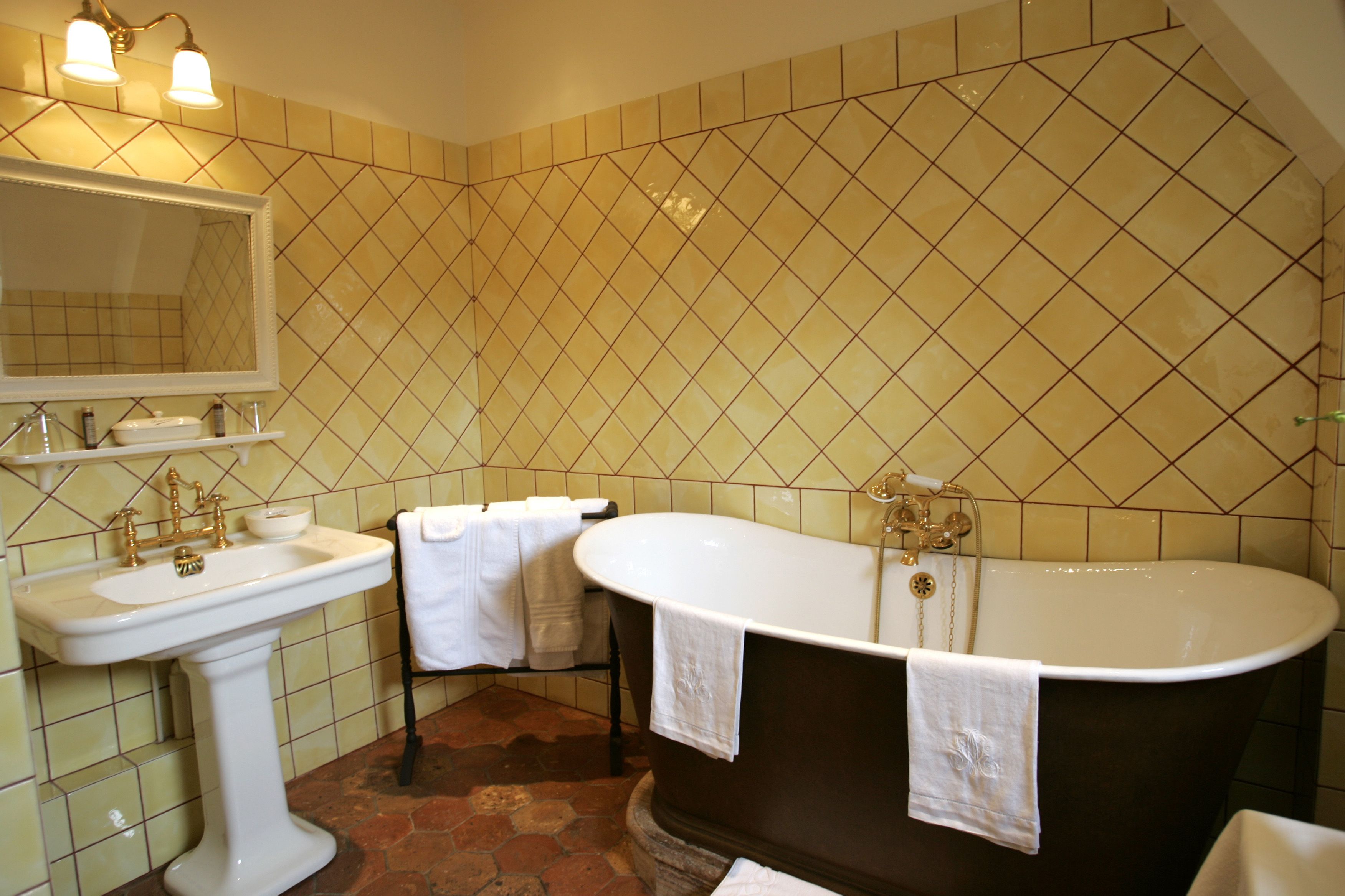 A bathroom with a sink, mirror, and bathtub.