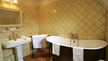 A bathroom with a sink, mirror, and bathtub.
