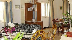 A living room with a sofa, a dining table with chairs, a bookshelf, and a chandelier. - Villa Veduta (Ghajnsielem)
