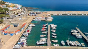 Un puerto deportivo con barcos amarrados, un muelle y edificios con tejados rojos.