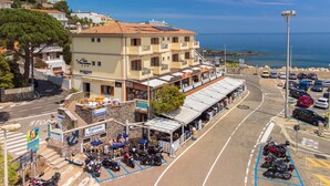Un hotel con recepción, asientos al aire libre y vista al mar.