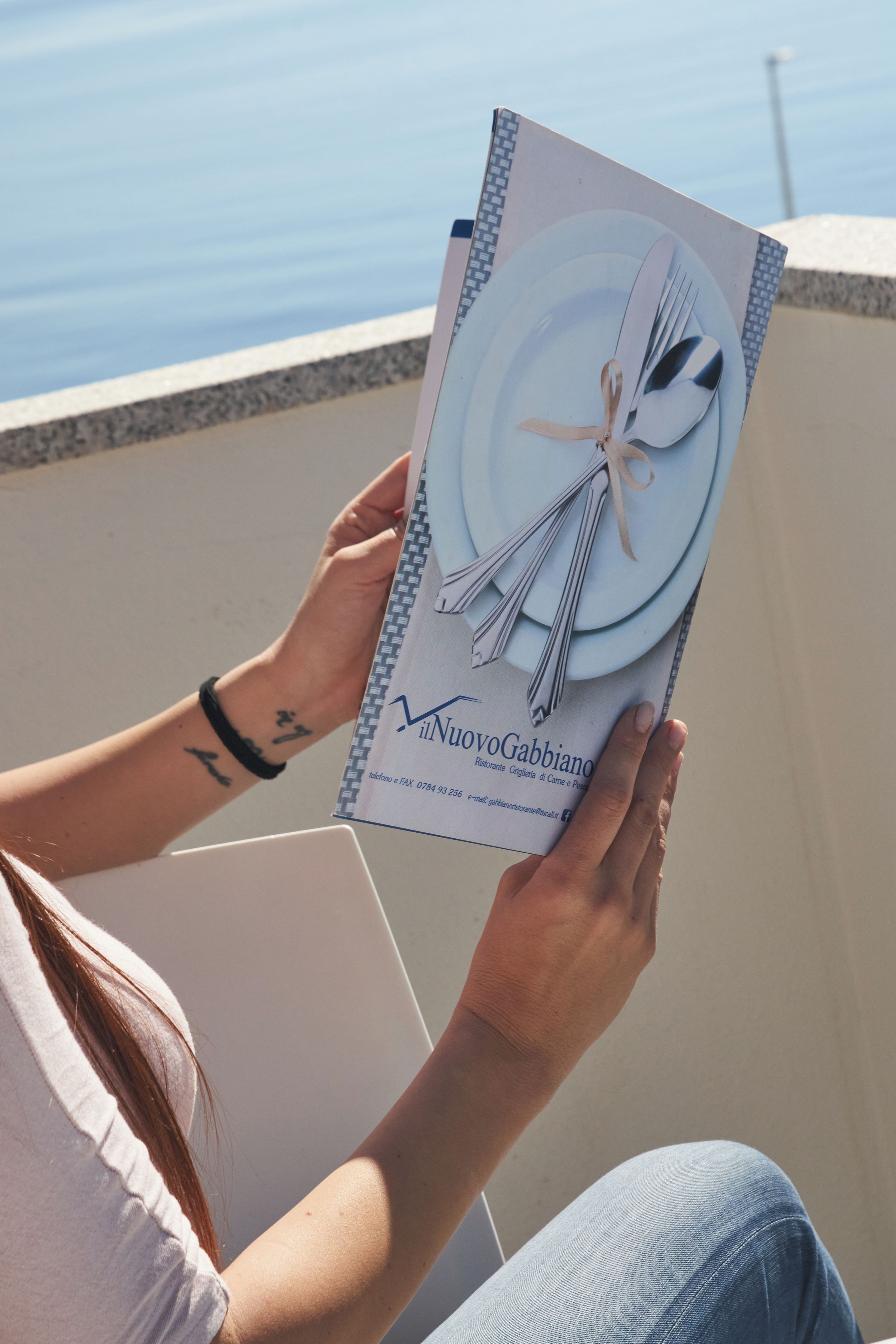 A person holding a menu with a plate and cutlery illustration.