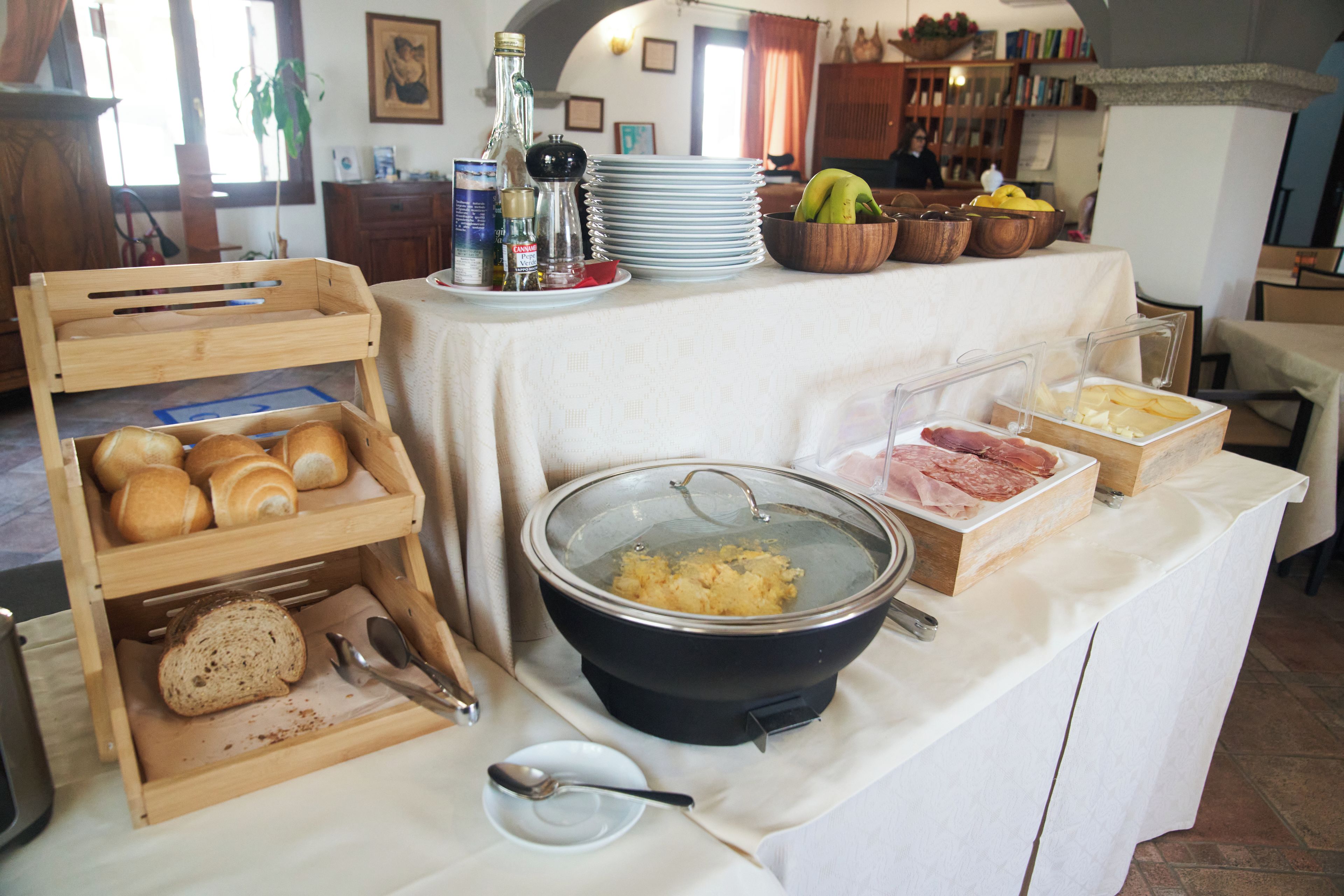 A buffet table with bread, cheese, meats, and condiments.