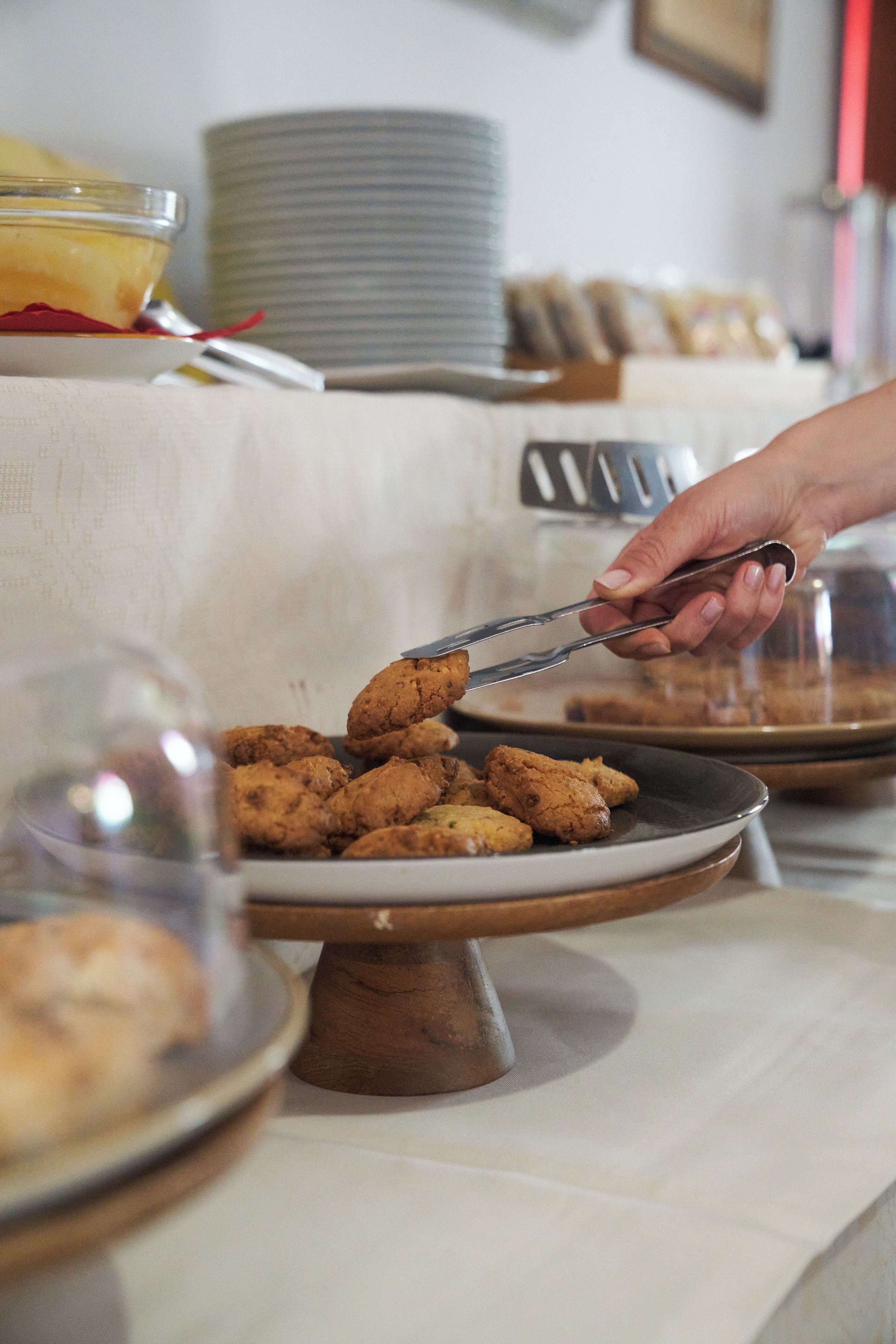 A buffet table with various food items, including cookies and a dessert.