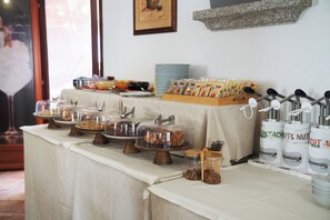 A buffet table with various food items and condiments.