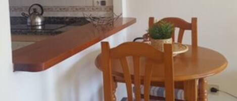A compact kitchen with an archway leading to a dining area.