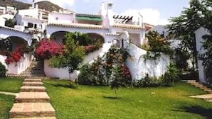 Um edifício branco com um caminho de pedra que leva à entrada.