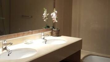 Separate bathtub and shower, towels, soap, shampoo