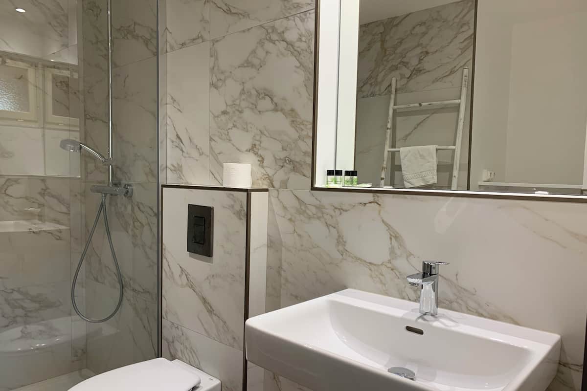 A bathroom with a toilet, a sink, and a shower.