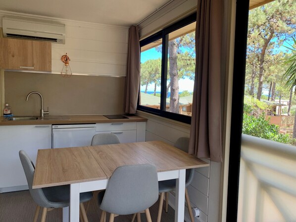 Uma cozinha compacta com pia, bancada pequena e janela com vista para um jardim.
