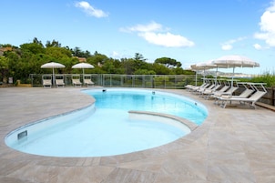 Una piscina al aire libre, tumbonas