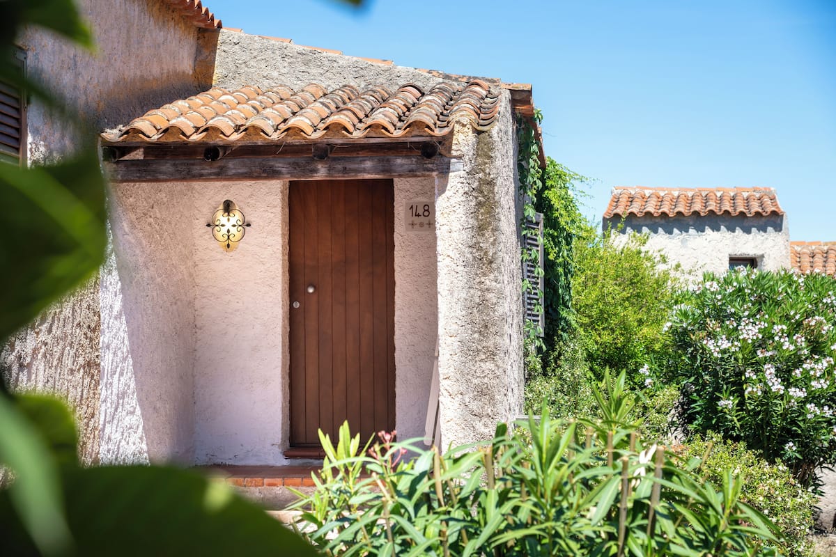 A rustic building with a tiled roof and a wooden door.