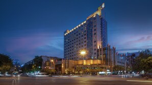 A high-rise hotel with multiple floors, illuminated windows, and a prominent entrance area with a canopy. - Chengdu Tianfu Sunshine Hotel (Chengdu)