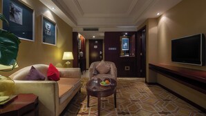 A hotel lobby with a sofa, armchair, and a small table with a fruit bowl. - Chengdu Tianfu Sunshine Hotel (Chengdu)