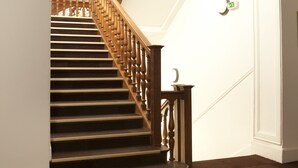A staircase with wooden balusters and a carpeted floor. - Le Château des Magnans (Jausiers)