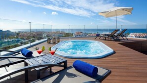 A rooftop pool area with a hot tub, lounge chairs, and a view of the ocean. - Hotel Best Tenerife (Arona)