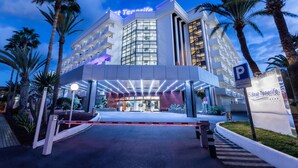 A hotel entrance with a modern design, palm trees, and a clear sky. - Hotel Best Tenerife (Arona)