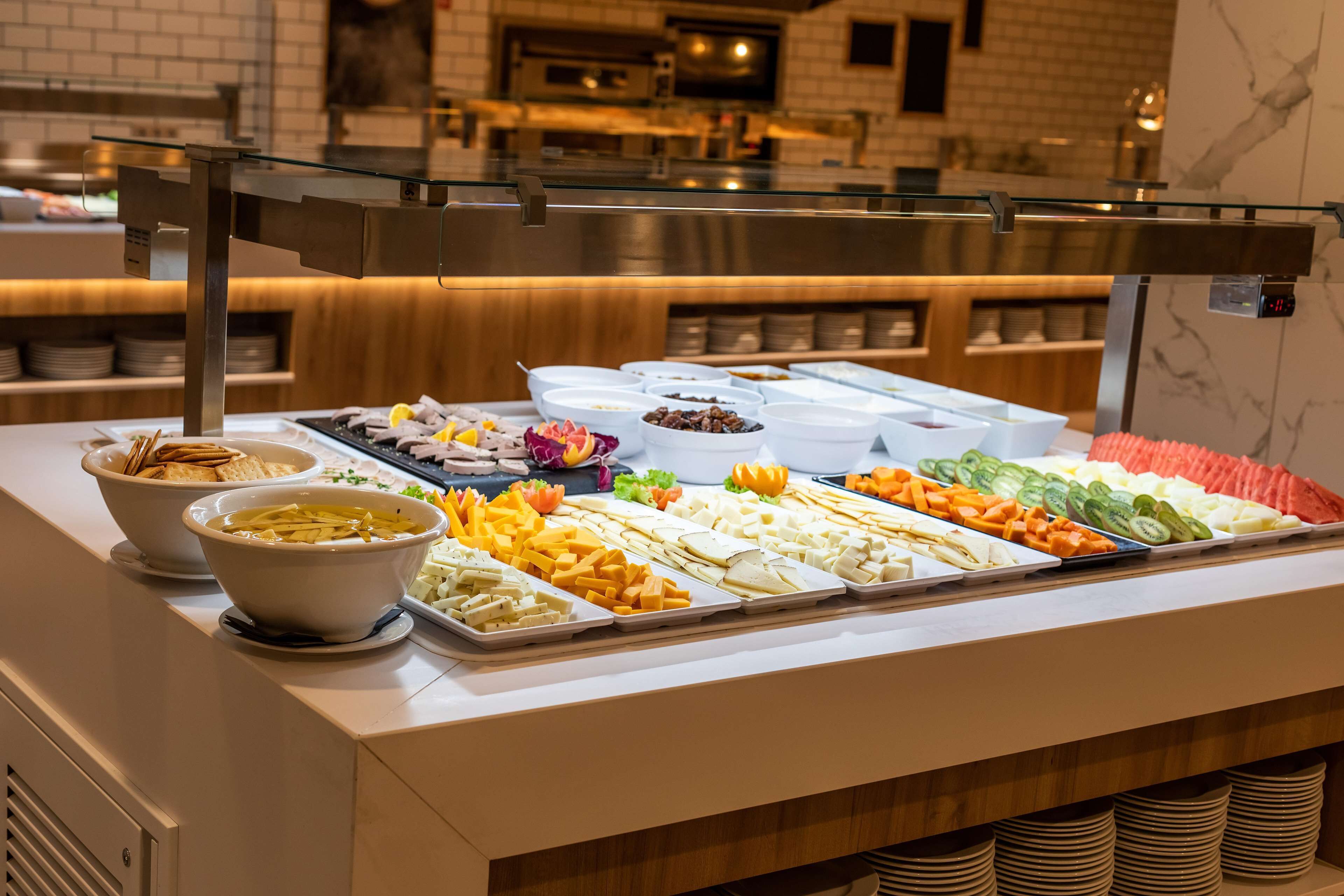 A buffet with various food items including fruits, cheeses, and crackers.