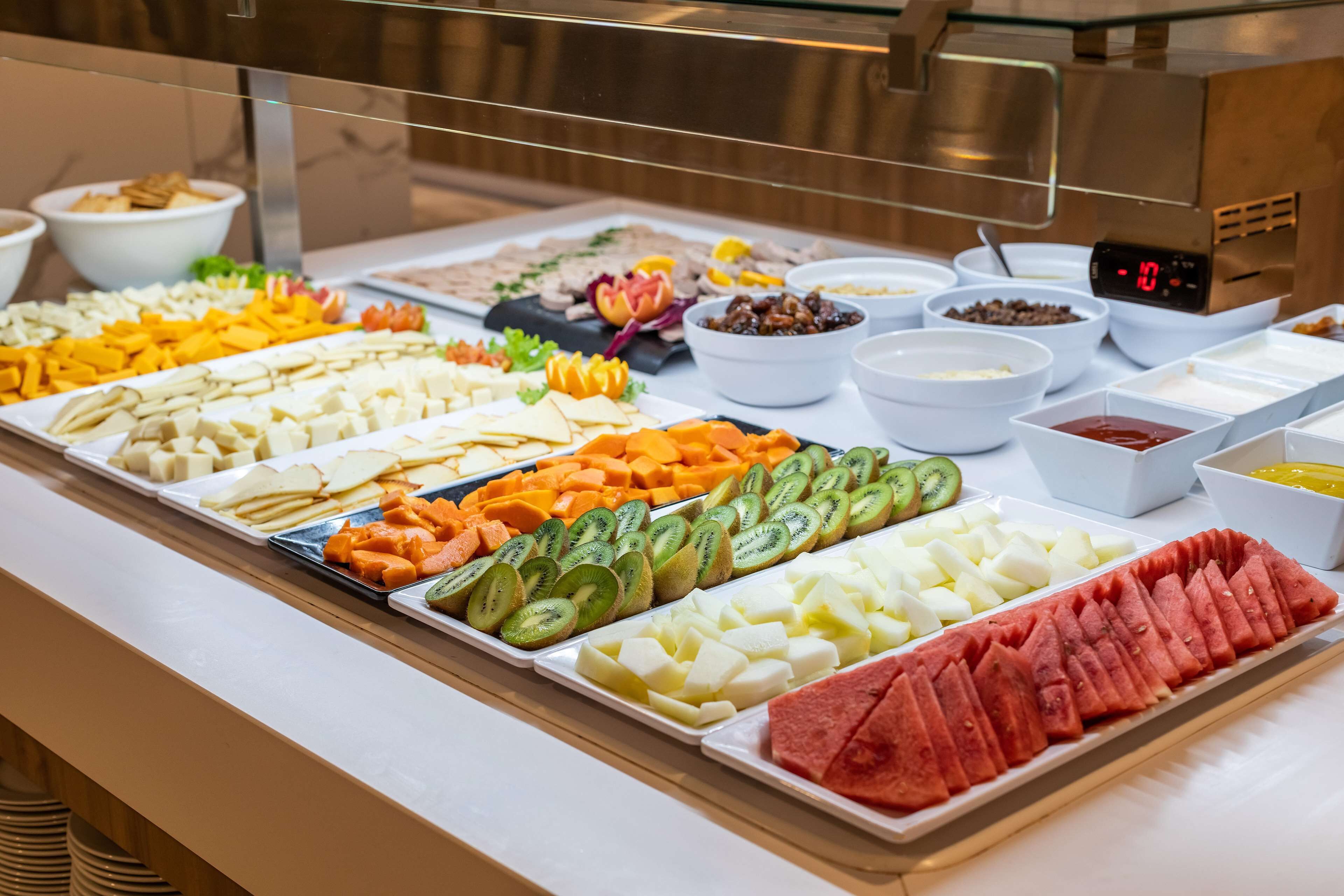 A buffet with various fruits and cheeses.