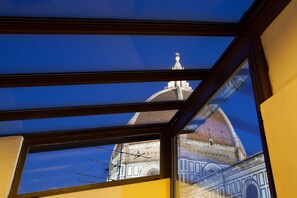 A view through a window of a building with a dome and a spire. - Granduomo Charming Accomodation (Florence)