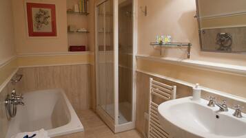 Une salle de bain avec une baignoire, une douche et un lavabo.