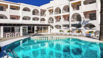 Ein Hotel mit Schwimmbad, Außenbereich und mehreren Balkonen.