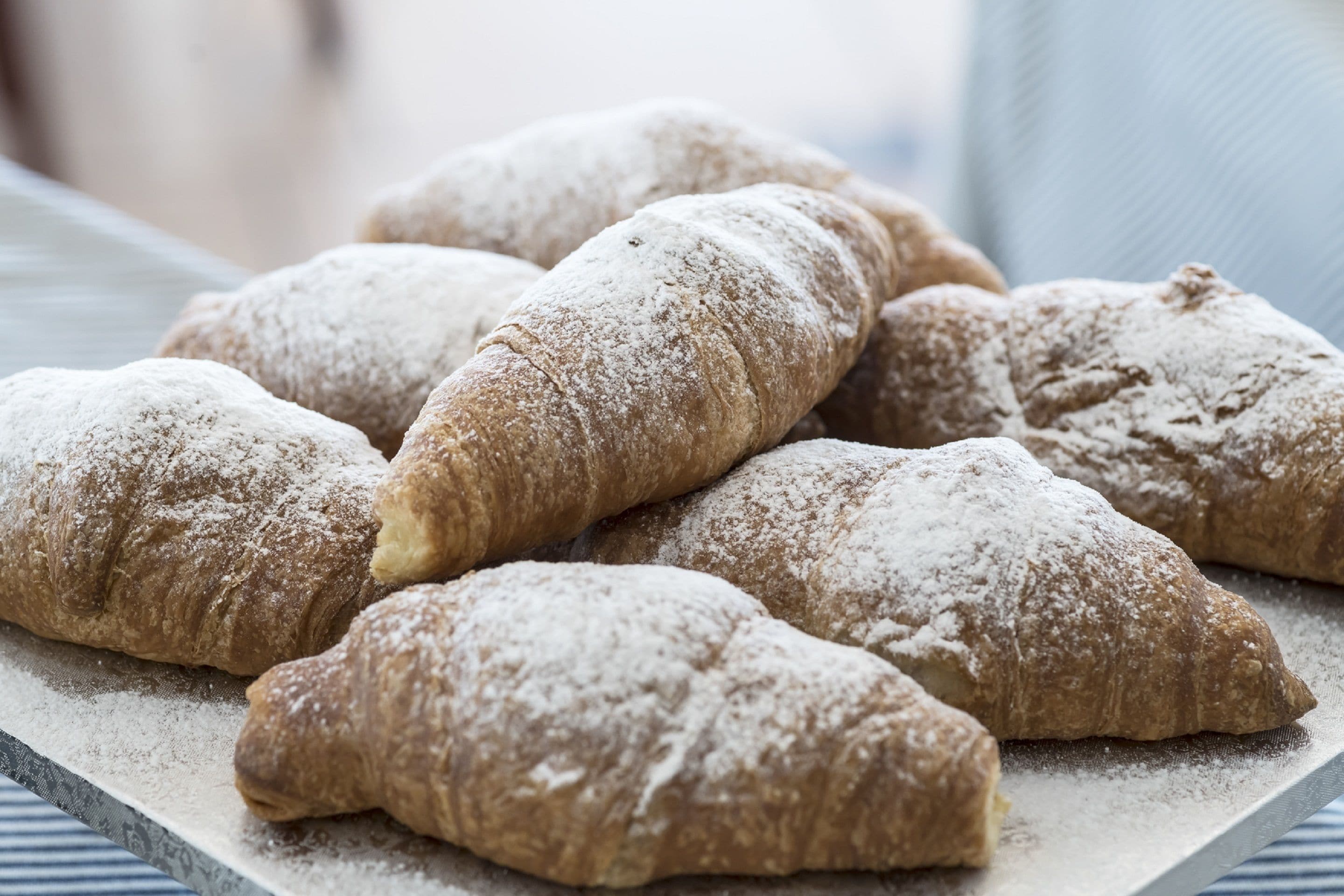 Un plateau de viennoiseries saupoudrées de sucre glace.