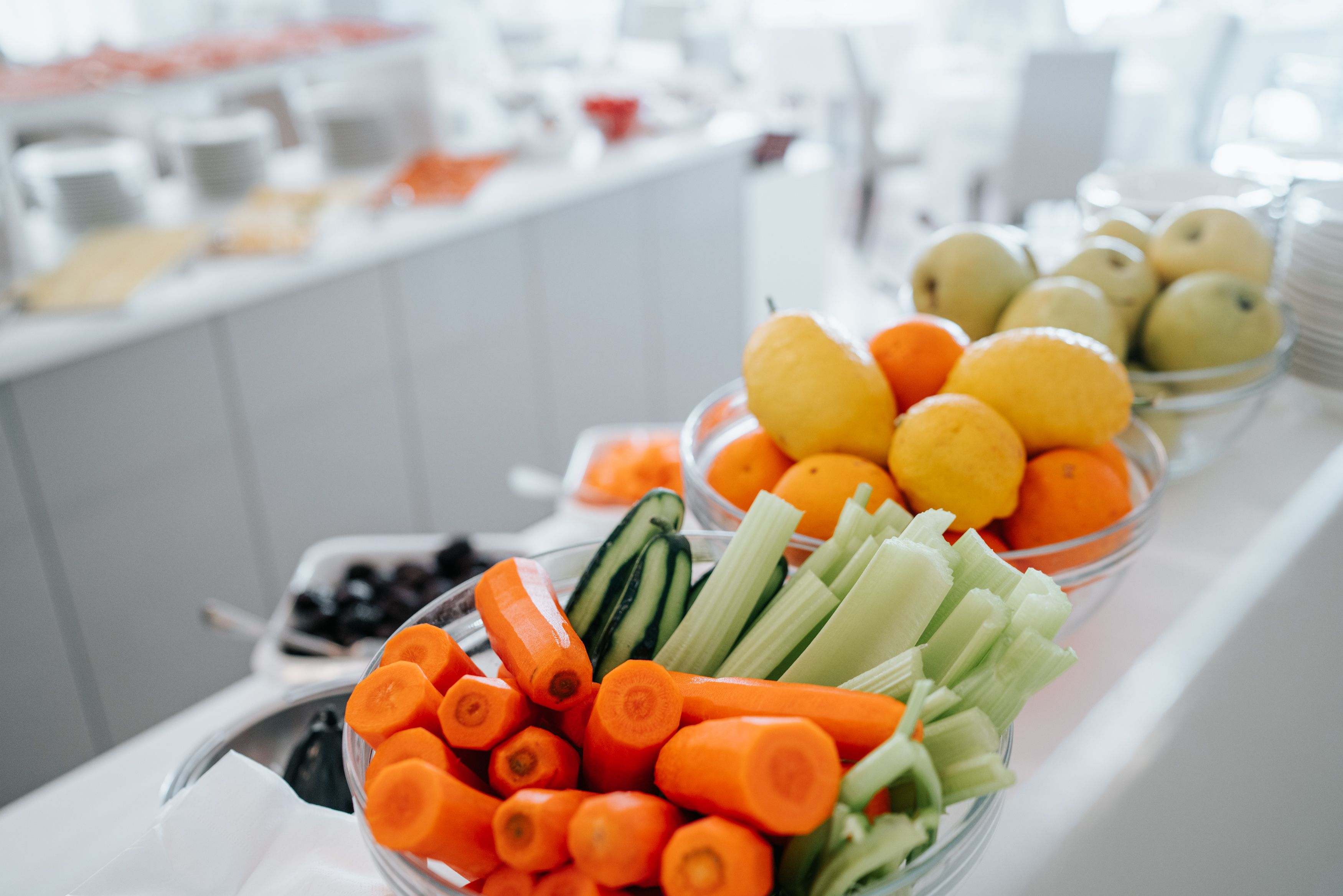 A buffet table with various fruits and vegetables.