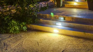 Un edificio con una escalera de piedra que lleva a una puerta, rodeado de vegetación.