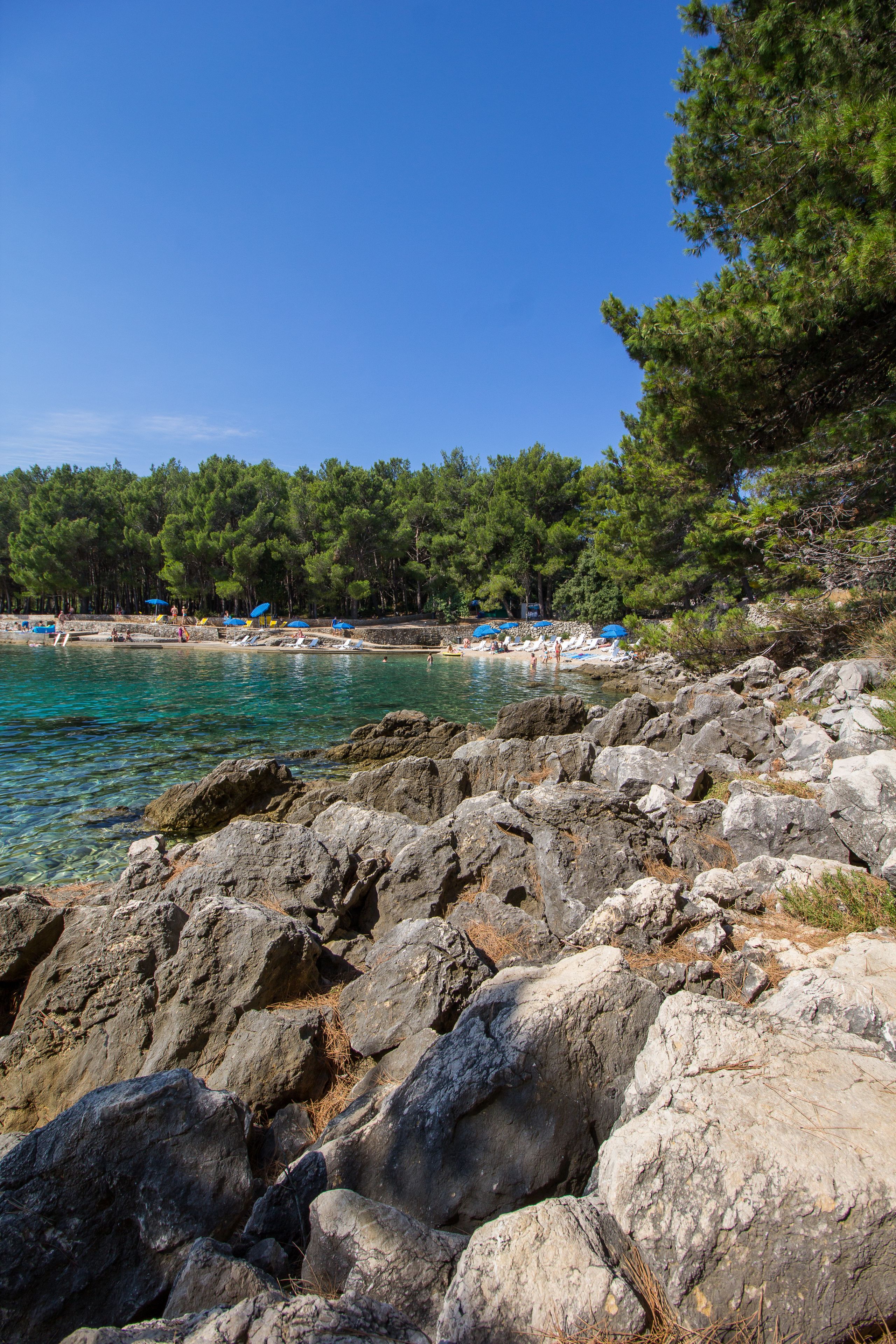 Pantai di sekitar, kursi berjemur, payung pantai, dan handuk pantai