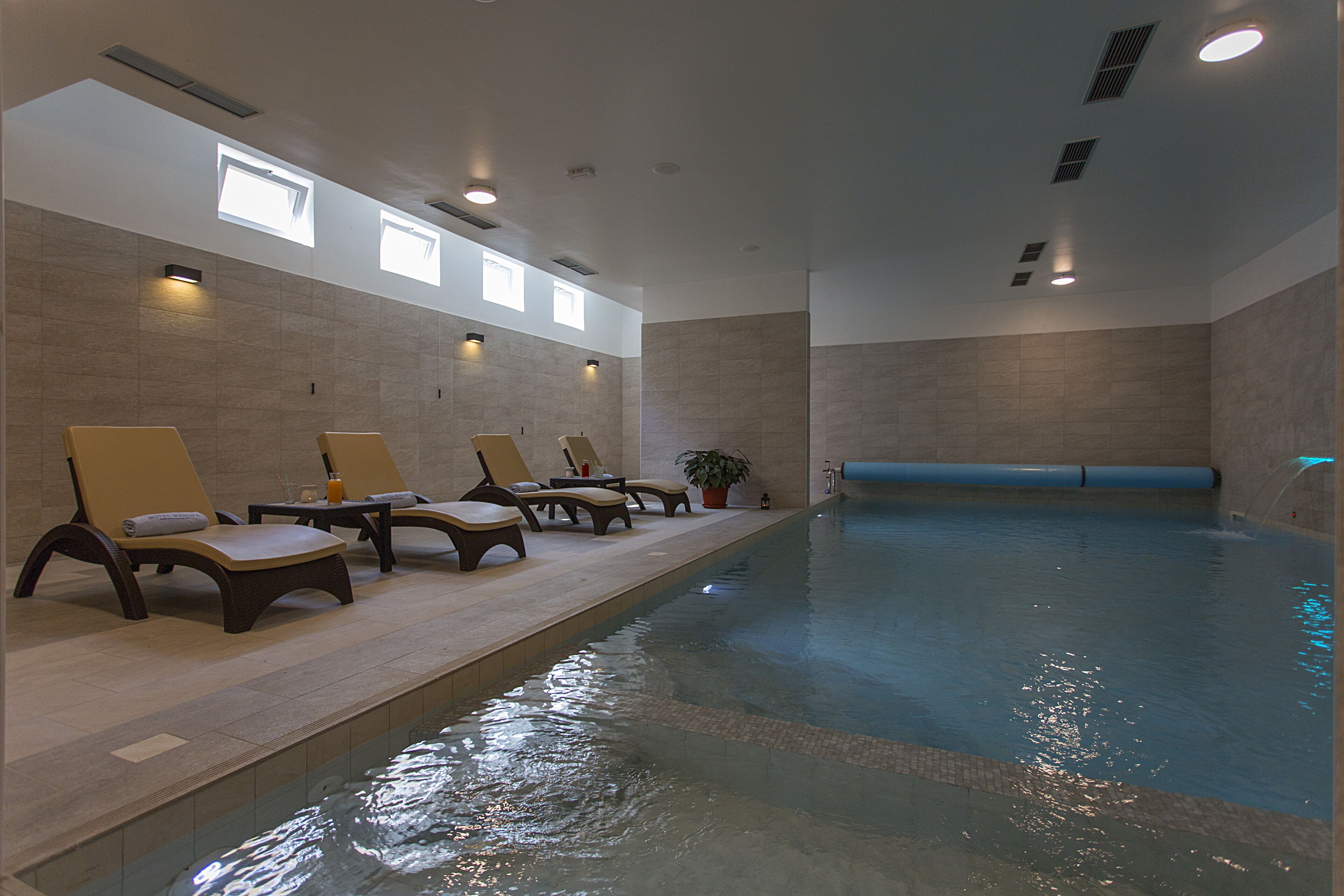 Ein Poolbereich mit Liegestühlen und einer blauen Wasserrutsche.