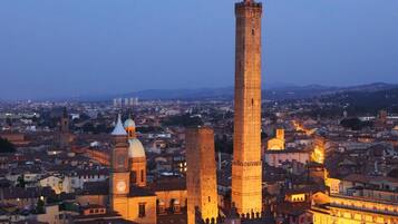 Un panorama storico con torri imponenti e un campanile, circondato da edifici residenziali.