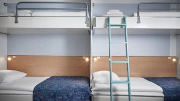 A hotel room with two beds, a wooden headboard, and a ladder between them.