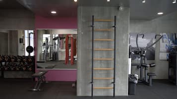 Et fitnessrum med en betondækker, en pull-up stang og vægtstativer.