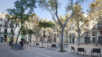 Una plaza al aire libre con bancos y bicicletas, rodeada de árboles y edificios.