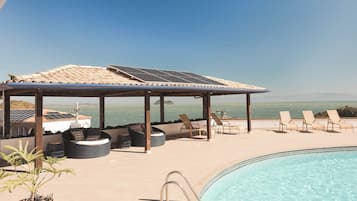 Een buitenzwembad, parasols voor strand/zwembad