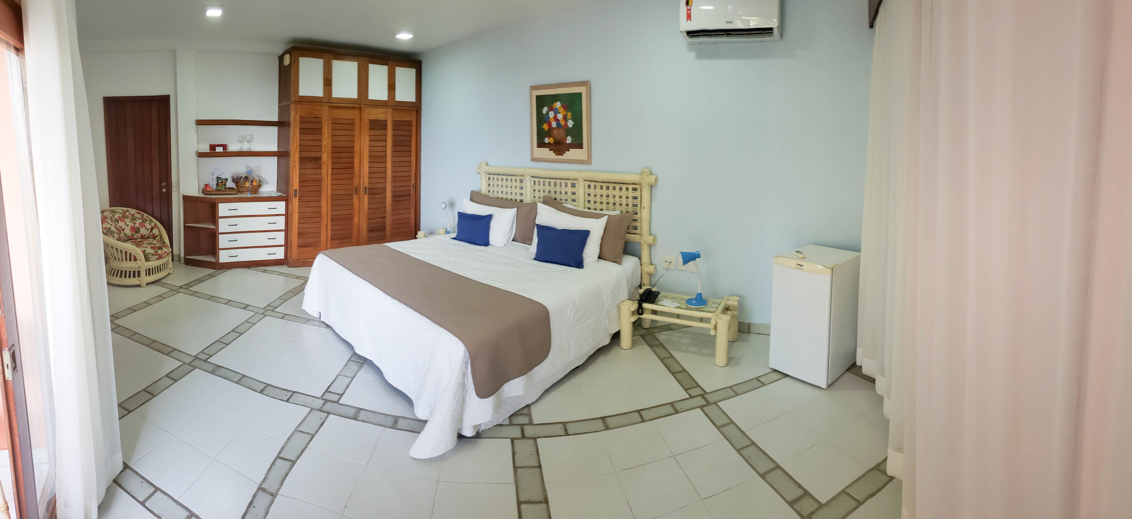 A bedroom with a bed, bedside table, wardrobe, and a small cabinet.